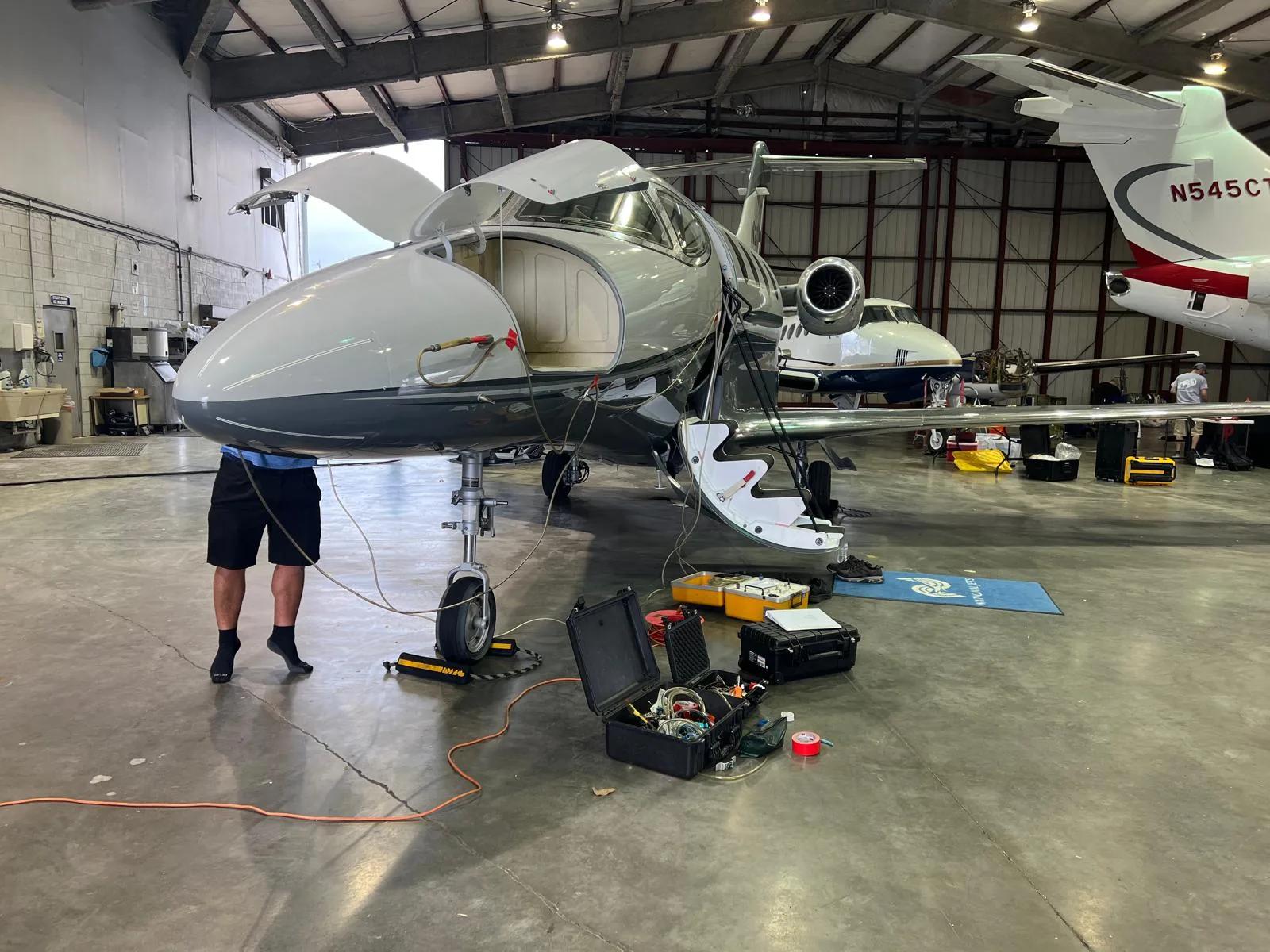 Business aircraft undergoing maintenance inside a hangar